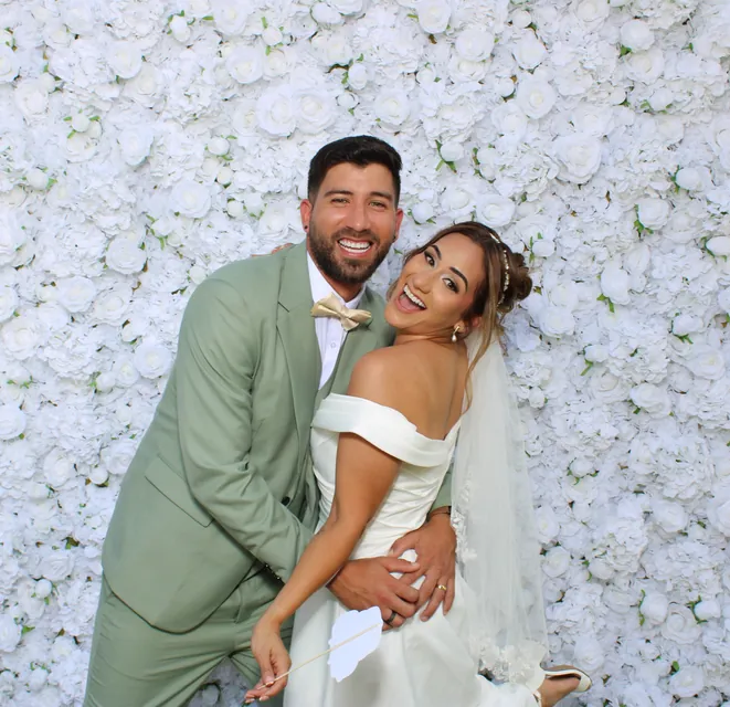 The Valbuenas wedding guests at the white flower wall