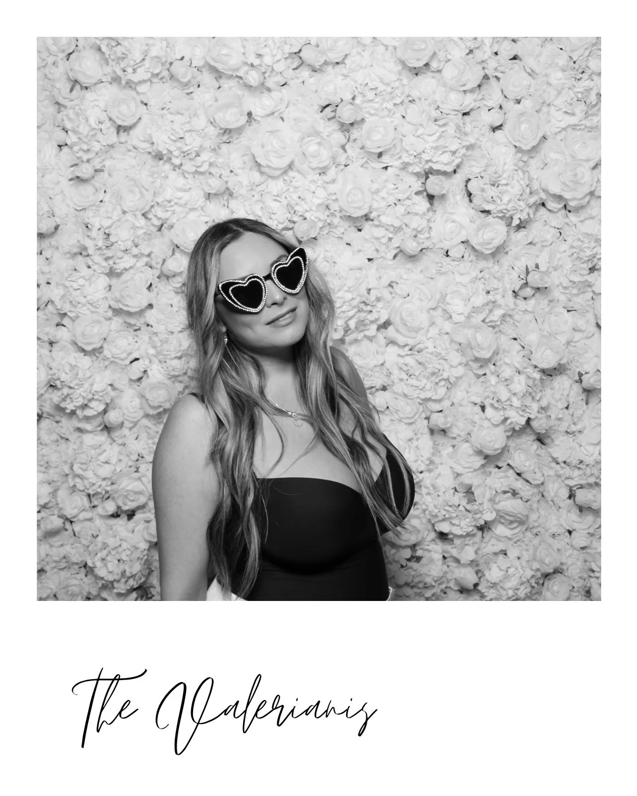 Black and white glam print of a guest in heart sunglasses at the flower wall, The Valerianis
