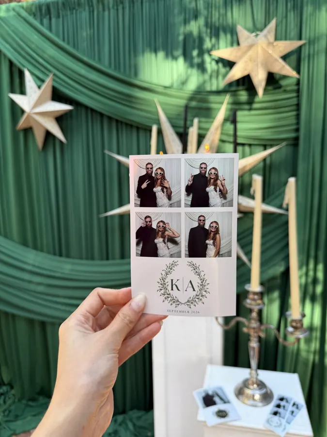 K|A monogram print held in front of emerald drapery and paper stars