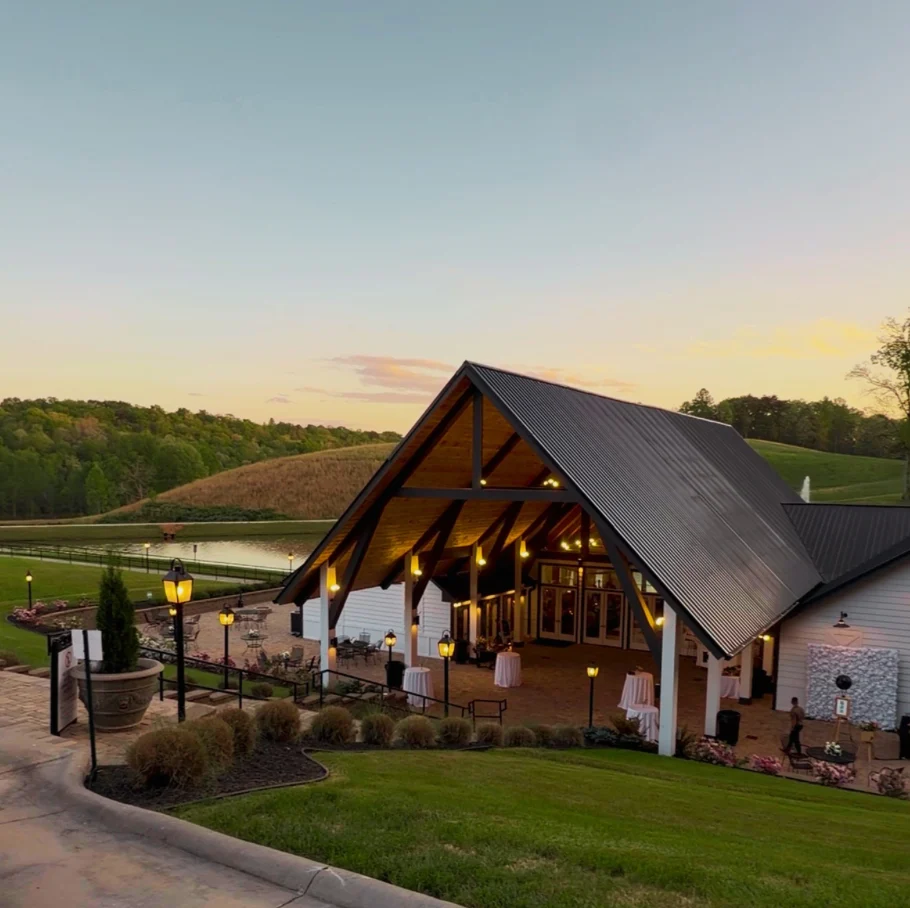 Swan Lake Overlook at sunset: the open-air pavilion with lantern-lit patio, lawn and lake