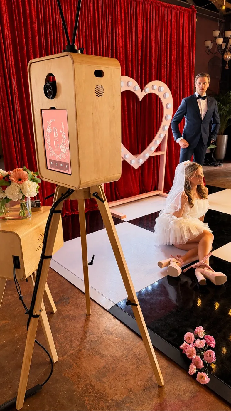 DSLR booth with a pink B|G floral monogram welcome screen, red velvet and a marquee heart